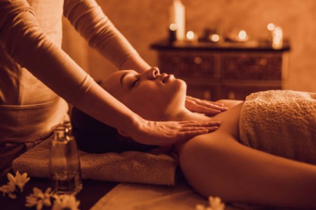 Serene African American woman receiving shoulder massage at beauty spa.